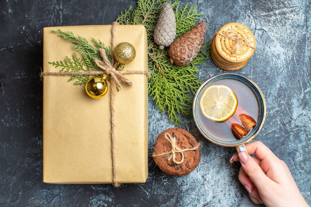 Vista superior de Navidad presente con galletas dulces y una taza de té en el fondo claro-oscuro