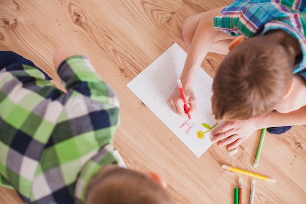 Foto gratuita vista superior de niño dibujando para el día de la madre