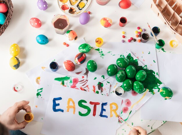 Vista superior niño pintando huevos de pascua tradicionales