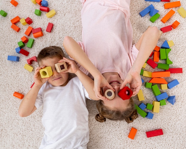 Foto gratuita vista superior de niños no binarios jugando con un juego colorido