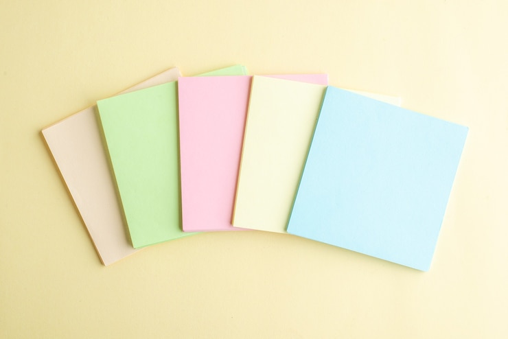 Foto gratuito vista superior de notas de papel de colores sobre fondo claro cuaderno de notas de la oficina de la escuela bolígrafo de negocios trabajo dinero trabajo del banco