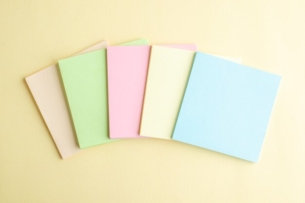 Vista superior de notas de papel de colores sobre fondo claro cuaderno de notas de la oficina de la escuela bolígrafo de negocios trabajo dinero trabajo del banco