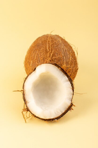 Una vista superior de nueces de coco en rodajas lechosas frescas suaves aisladas en color crema