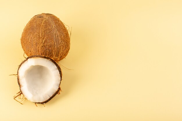 Una vista superior de nueces de coco en rodajas lechosas frescas suaves aisladas en color crema