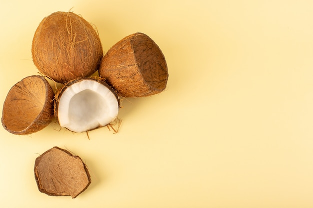 Una vista superior de nueces de coco en rodajas lechosas frescas suaves aisladas en color crema