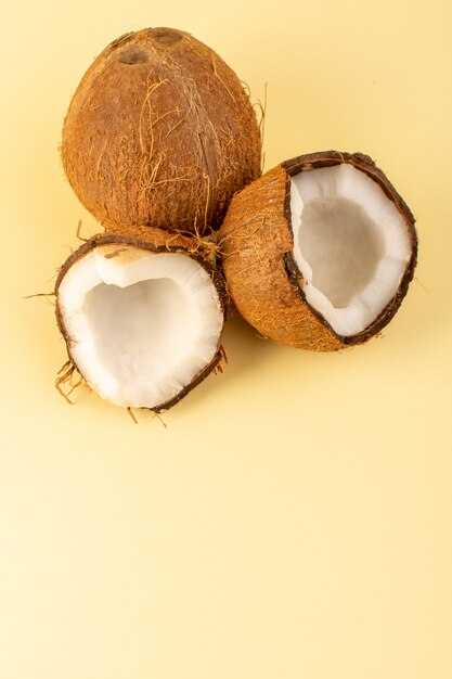 Una vista superior de nueces de coco en rodajas lechosas frescas suaves aisladas en color crema