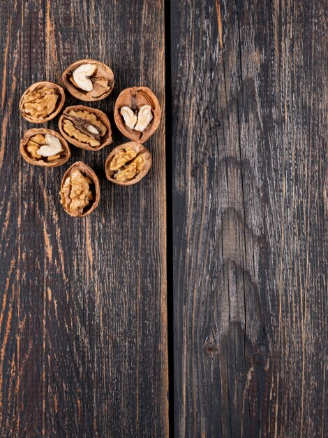 Vista superior de nueces con espacio de copia en vertical de madera