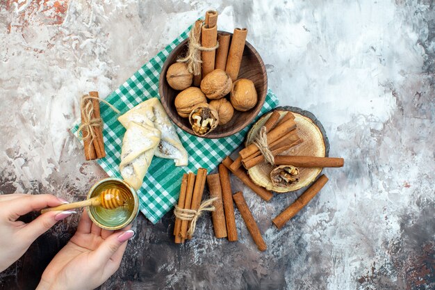 Vista superior de nueces frescas con canela y pastelería dulce sobre una superficie blanca