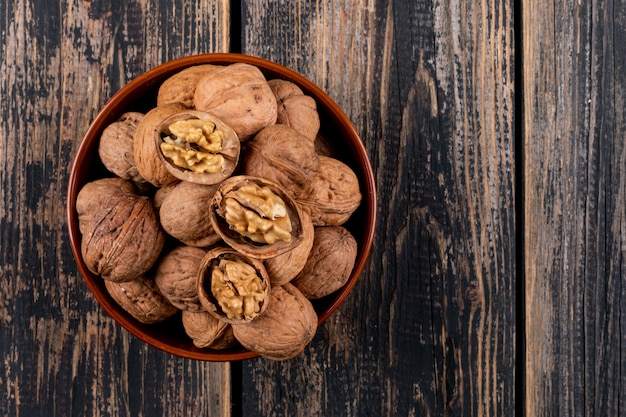 Foto gratuita vista superior de nueces en un tazón en madera horizontal