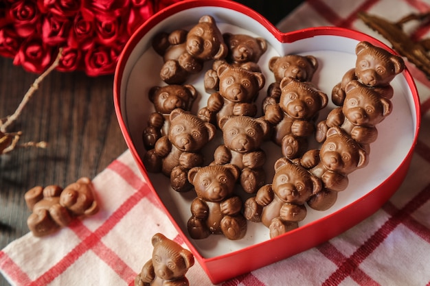 Foto gratuita vista superior de osos de chocolate en una caja roja en forma de corazón