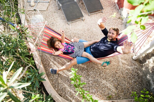 Vista superior de padre e hija descansando en una hamaca