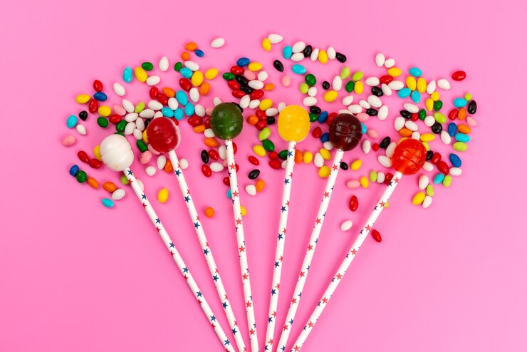 Foto gratuito una vista superior de paletas de colores junto con caramelos de colores en rosa, azúcar dulce de color