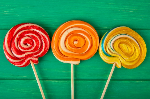 Foto gratuita vista superior de paletas de colores sobre un palo sobre fondo de madera verde