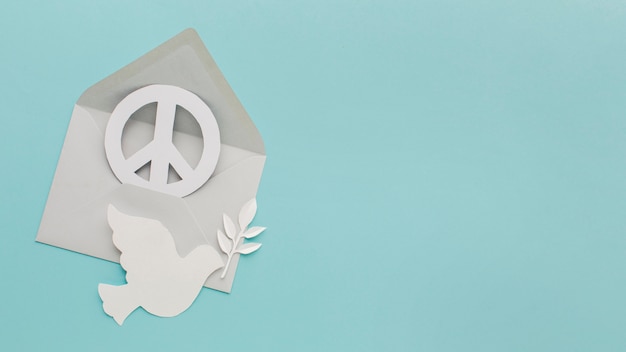 Vista superior de la paloma de papel con sobre y signo de la paz