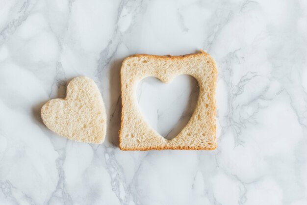 Vista superior de pan con corazón sobre fondo mabrle