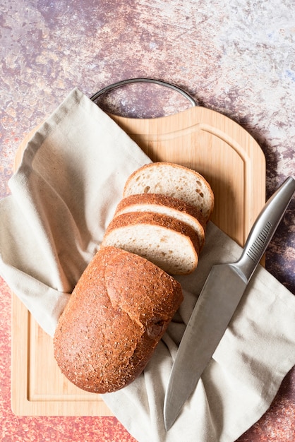 Vista superior de pan de molde con tabla de cortar y cuchillo