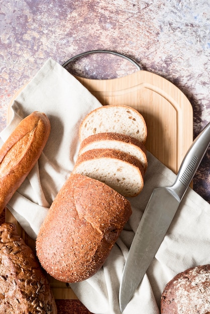 Vista superior de pan de molde con toalla de cocina y cuchillo