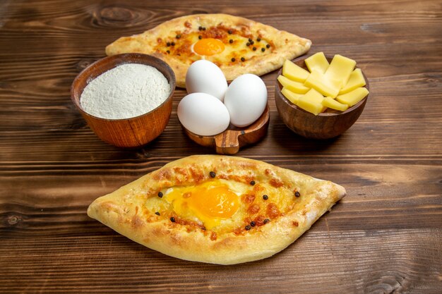 Vista superior panes de huevo horneados recién salidos del horno en el escritorio de madera marrón masa pan de huevo pan de desayuno