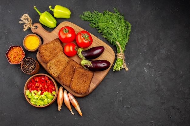 Vista superior panes de pan oscuro con condimentos tomates y berenjenas en el fondo oscuro ensalada salud comida madura