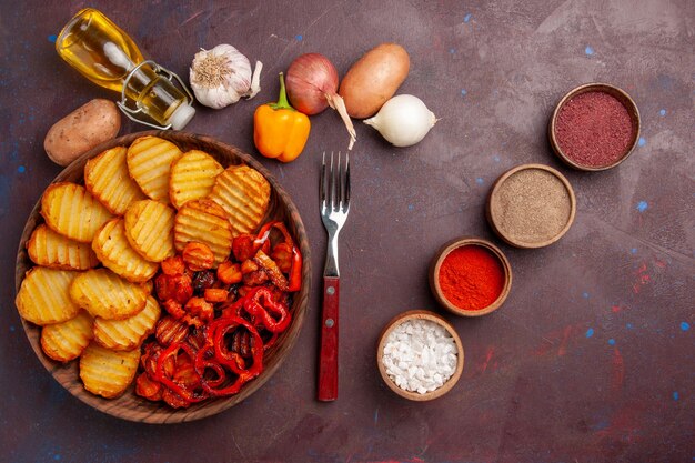 Vista superior de papas al horno con condimentos en un espacio de color púrpura oscuro