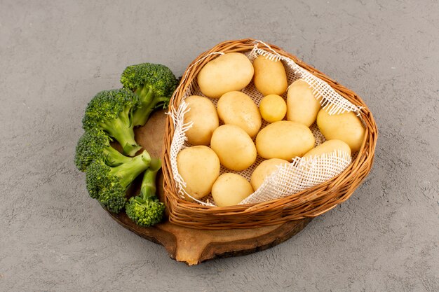 Vista superior de papas con brócoli verde sobre el fondo gris