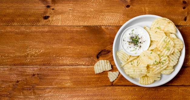 Vista superior de papas fritas en un plato con salsa y espacio de copia