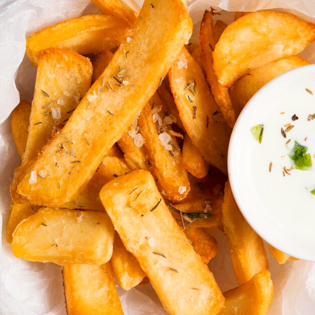 Vista superior de papas fritas saladas con salsa especial