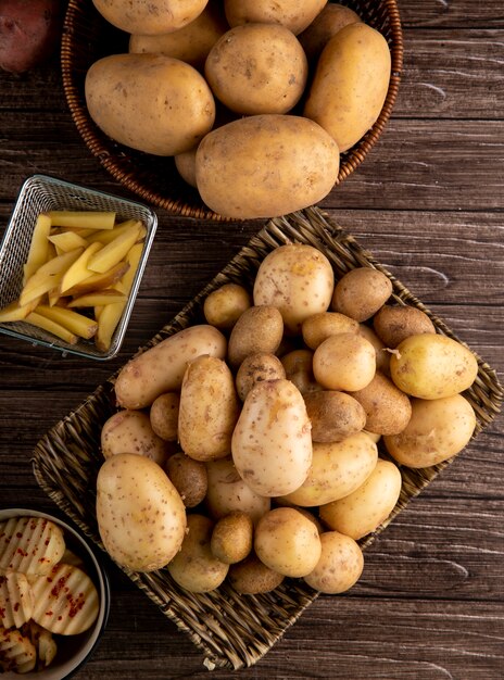 Vista superior de papas jóvenes en canasta sobre fondo de madera