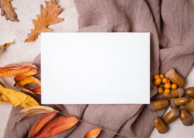 Vista superior de papel con hojas de otoño y bellotas.