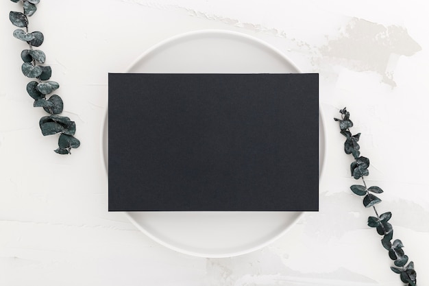 Foto gratuita vista superior del papel de menú en blanco en un plato con plantas