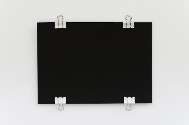 Vista superior de papel negro con clips de metal en los lados.