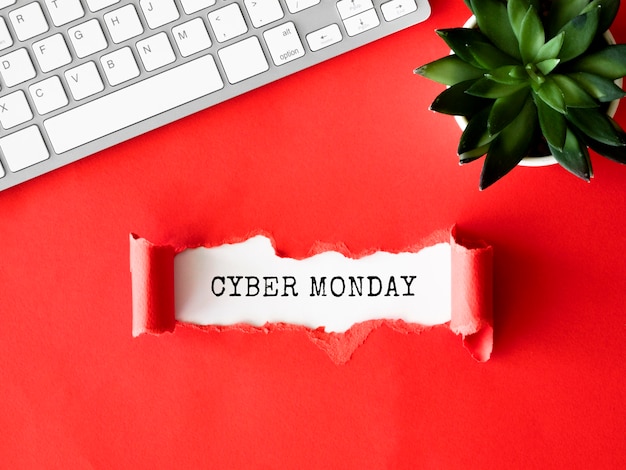 Vista superior de papel rasgado con teclado y planta para cyber monday