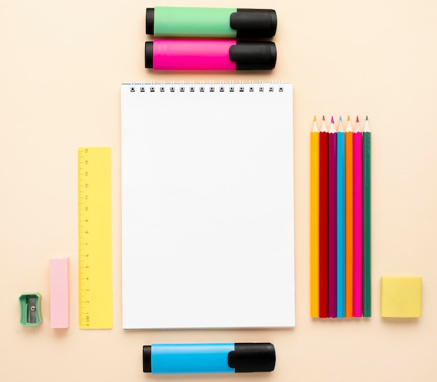 Vista superior de papelería de regreso a la escuela con cuaderno y lápices de colores