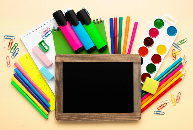 Vista superior de papelería de regreso a la escuela con lápices de colores y acuarela