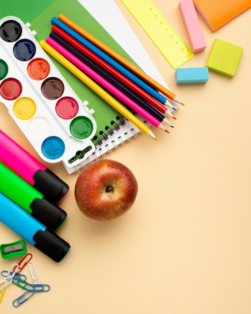 Vista superior de papelería de regreso a la escuela con manzana y lápices de colores