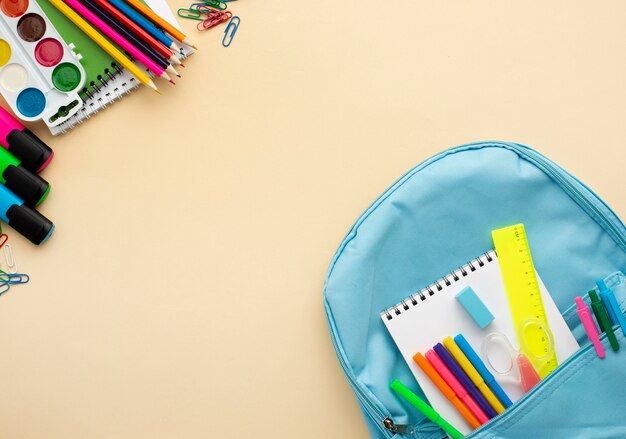 Vista superior de papelería de regreso a la escuela con mochila y lápices de colores