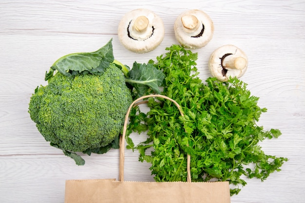 Vista superior de un paquete de brócoli de setas verdes frescas en una canasta sobre fondo blanco.