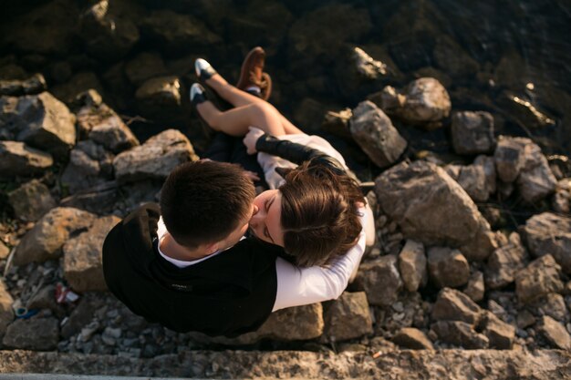 Vista superior de pareja enamorada sentados en las rocas