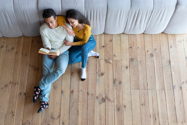 Vista superior de una pareja encantadora leyendo un libro