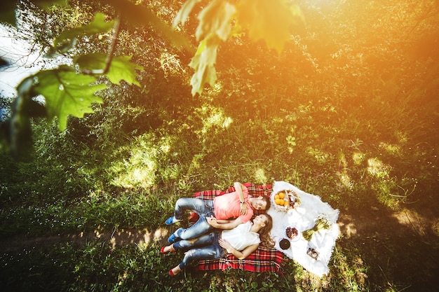 Vista superior de pareja feliz tumbada en el césped en un día soleado