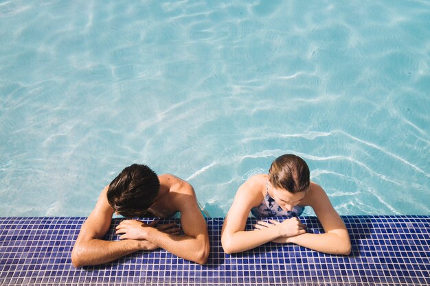 Vista superior de pareja joven en piscina