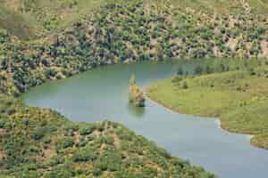 Foto gratuita vista superior del parque nacional de monfragüe en españa. altas montañas y colinas cubiertas de verde con un río