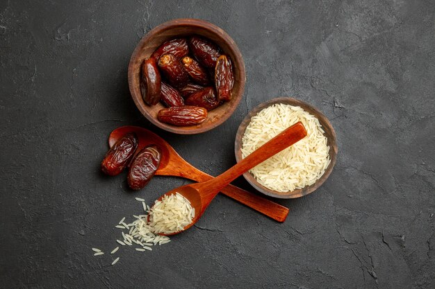 Vista superior pasas secas con arroz crudo sobre una superficie oscura pasas de frutos secos