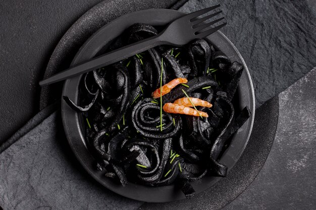 Vista superior de pasta de camarones negros con tenedor