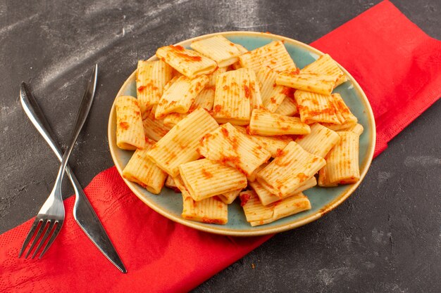 Una vista superior de pasta italiana cocida con salsa de tomate dentro de la placa