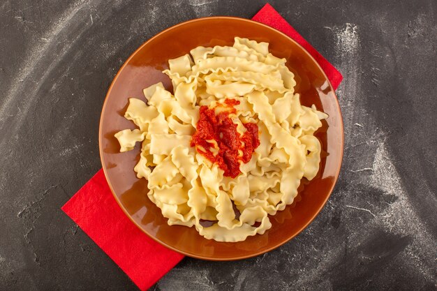 Una vista superior de pasta italiana cocida con salsa de tomate dentro de la placa