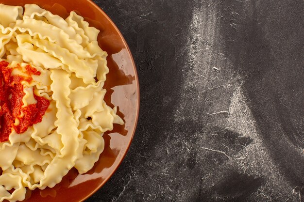 Una vista superior de pasta italiana cocida con salsa de tomate dentro de la placa