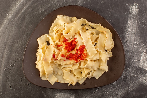 Una vista superior de pasta italiana cocida con salsa de tomate dentro de la placa