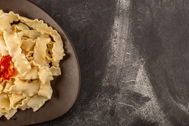 Una vista superior de pasta italiana cocida con salsa de tomate dentro de la placa