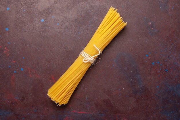 Vista superior de pasta italiana cruda formada durante mucho tiempo sobre fondo oscuro comida pasta pasta cruda